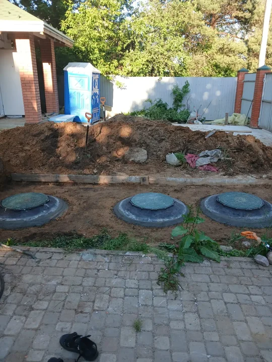 Септик из трёх колодцев рядом с домом: люки остались между плиткой и газоном